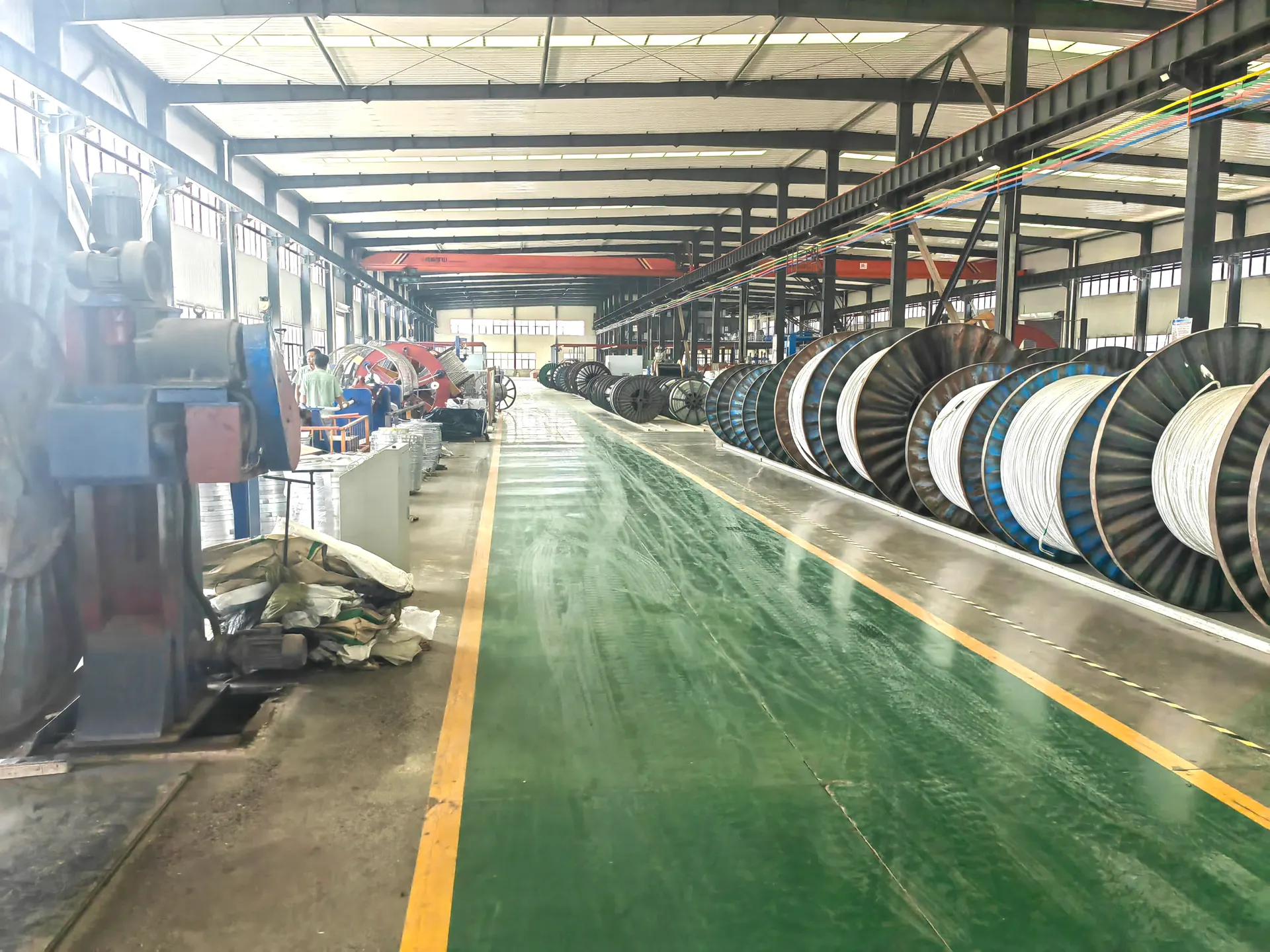Factory quality control technician performing high-voltage withstand test on cable drum with test equipment