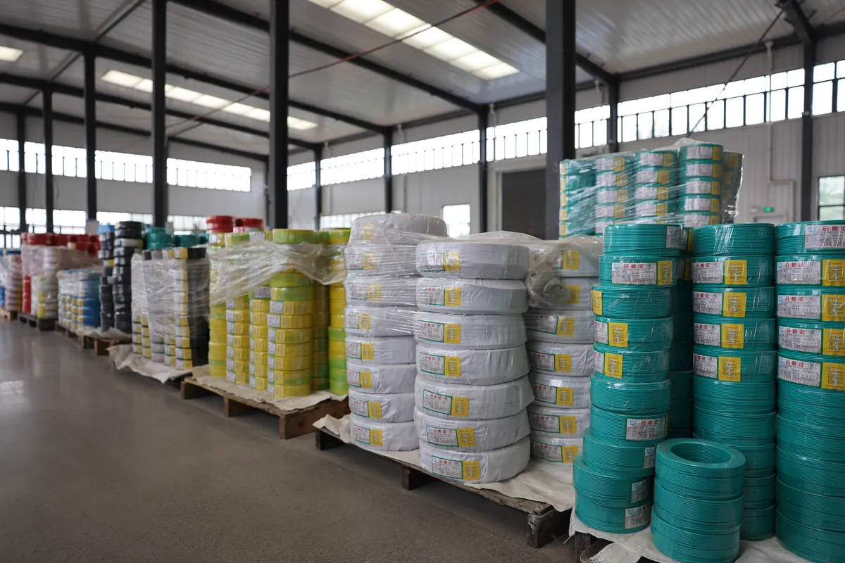 Finished cable drums stacked in the factory warehouse awaiting container loading for export
