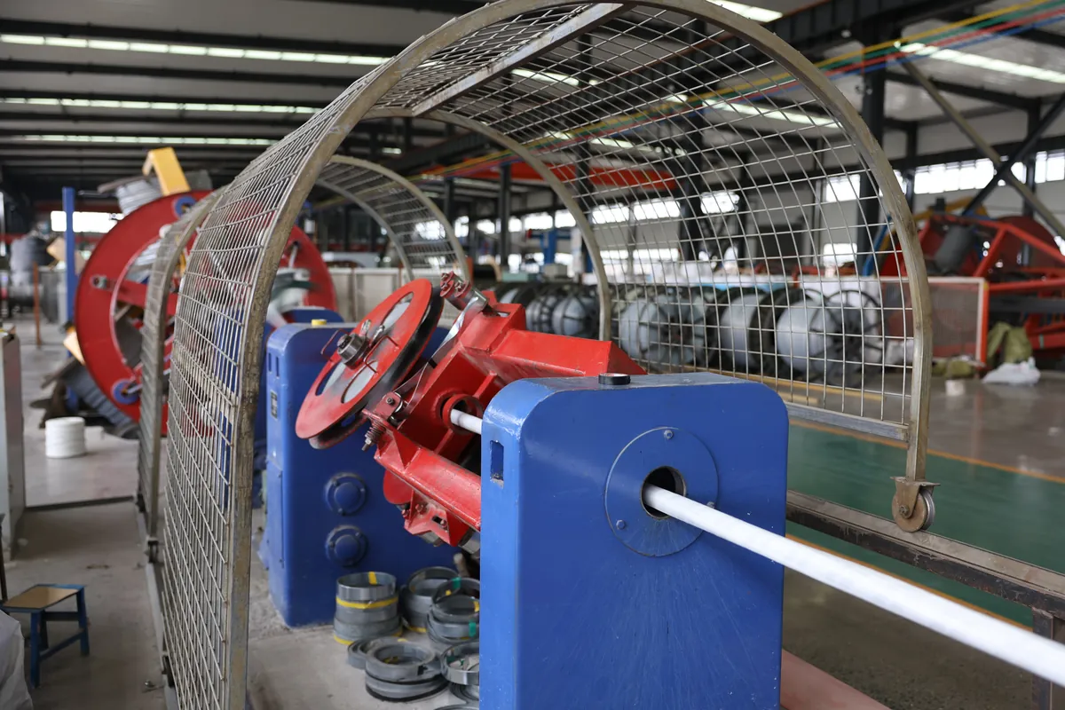 Galvanised steel wire armouring machine applying SWA over the laid-up cable core of a three-core medium voltage cable